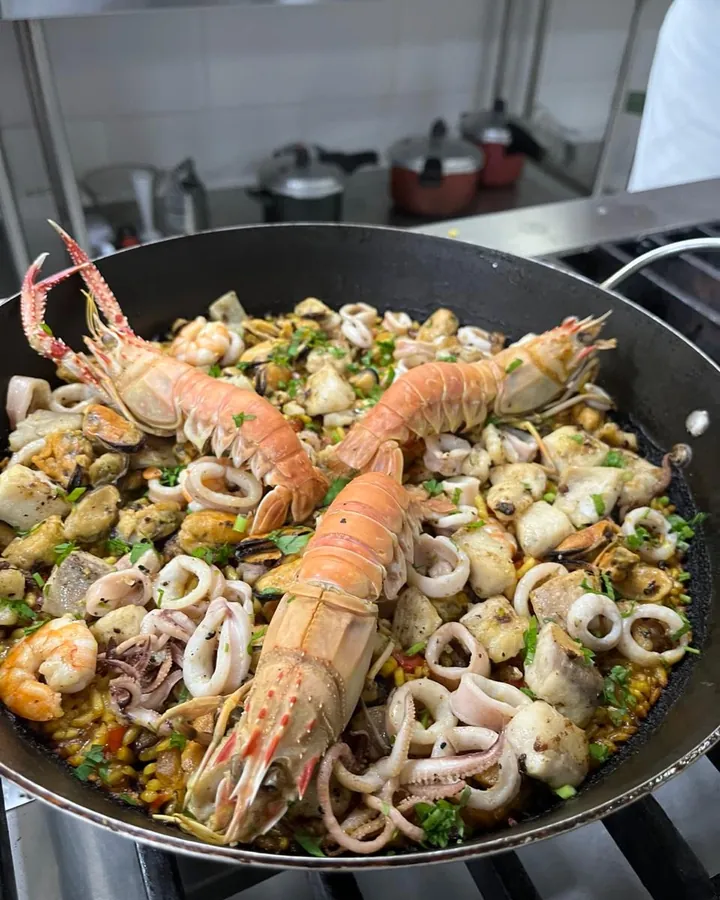 Paella com lagostins, lulas e frutos do mar na paellera, preparado pela Chef Angie